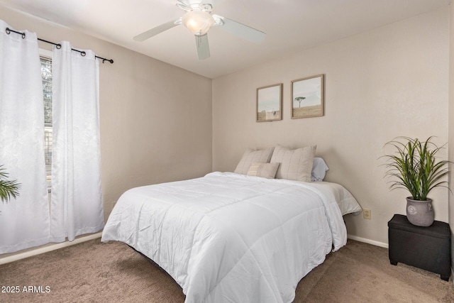 carpeted bedroom with ceiling fan and baseboards