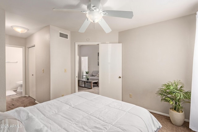 carpeted bedroom featuring a ceiling fan, baseboards, visible vents, and ensuite bathroom