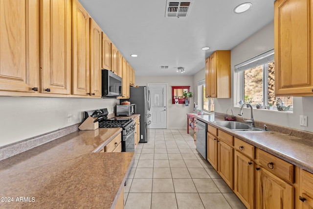 kitchen featuring light brown cabinets, stainless steel appliances, sink, and light tile patterned floors