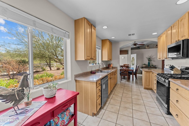 kitchen with appliances with stainless steel finishes, light tile patterned flooring, sink, ceiling fan, and light brown cabinets