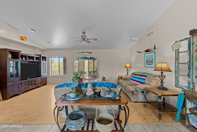 living room featuring light hardwood / wood-style floors, ceiling fan, and vaulted ceiling