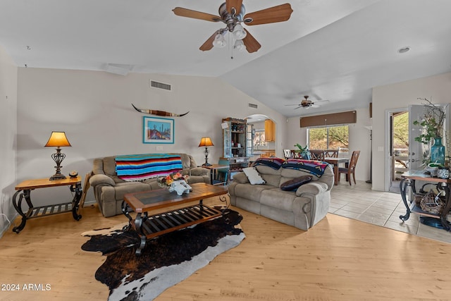 living room with ceiling fan, lofted ceiling, and light hardwood / wood-style flooring