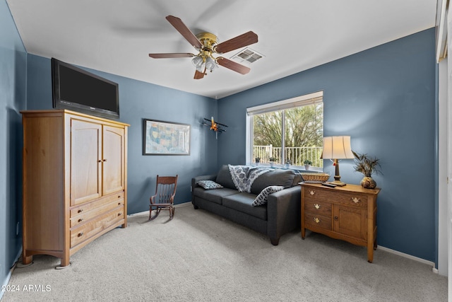 living area with light carpet and ceiling fan