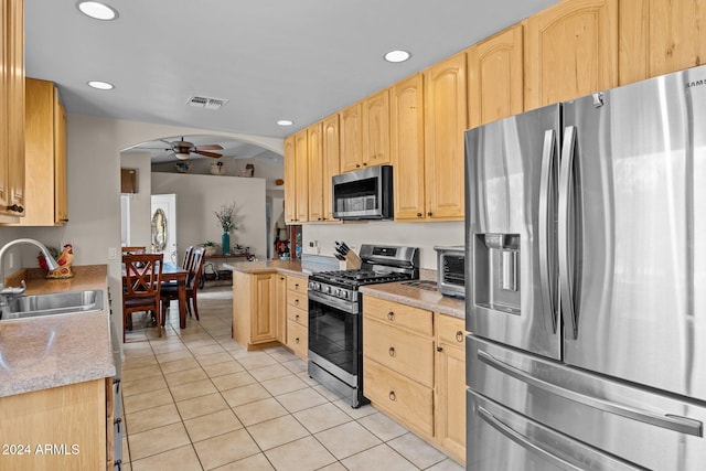 kitchen featuring light brown cabinetry, sink, ceiling fan, stainless steel appliances, and light tile patterned floors