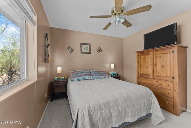 carpeted bedroom with multiple windows and ceiling fan