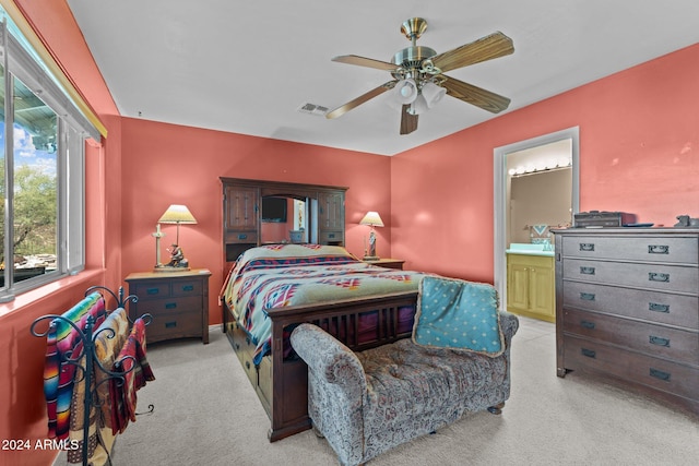 carpeted bedroom featuring ceiling fan and ensuite bath