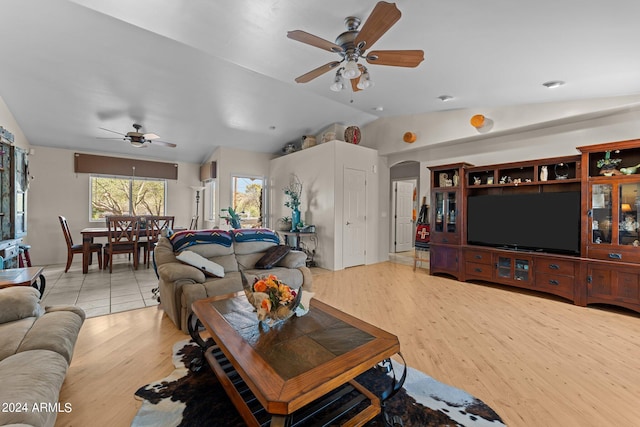 living room featuring lofted ceiling, light wood-type flooring, and ceiling fan