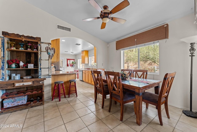 tiled dining room with lofted ceiling, sink, and ceiling fan