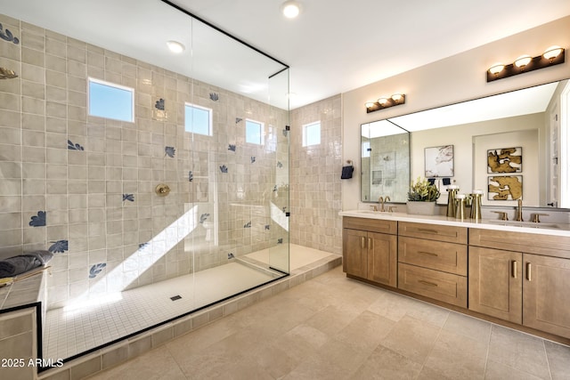 bathroom with a walk in shower, double vanity, and a sink