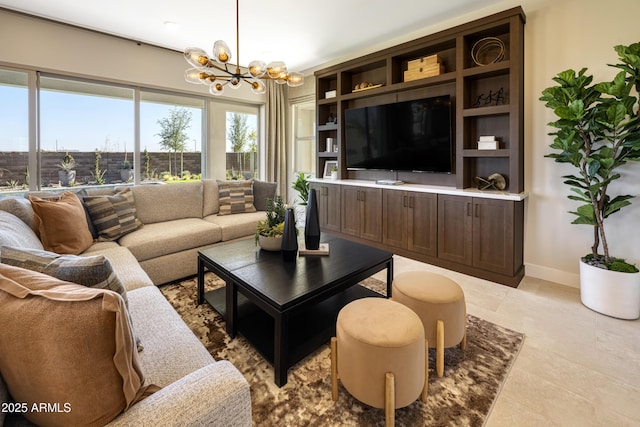 living room featuring a chandelier and baseboards