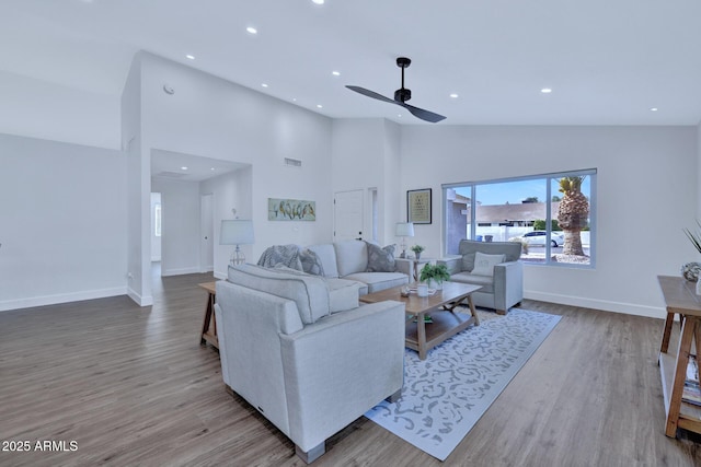 living room featuring ceiling fan, high vaulted ceiling, and light hardwood / wood-style floors