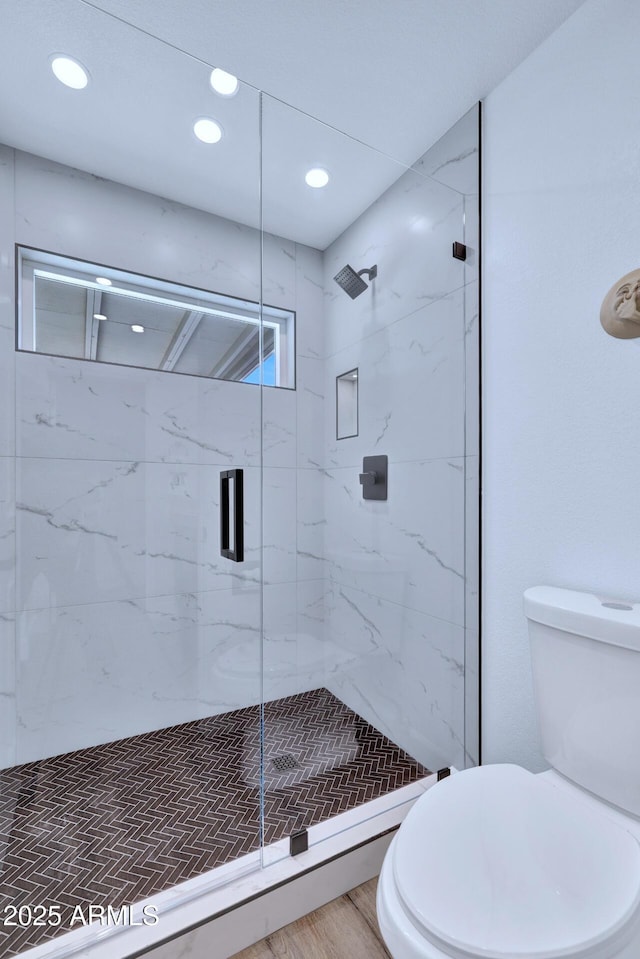 bathroom with walk in shower, wood-type flooring, and toilet