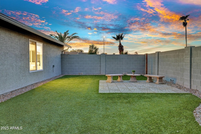 yard at dusk featuring a patio