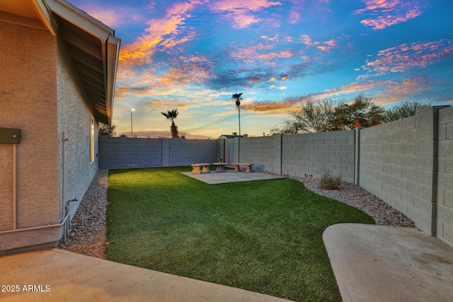 yard at dusk featuring a patio area