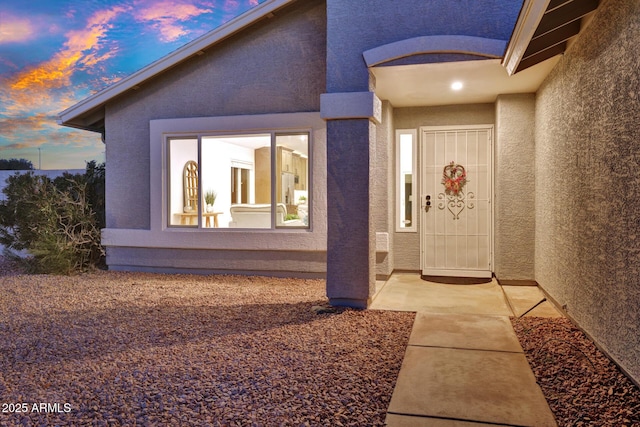 exterior entry at dusk featuring a patio