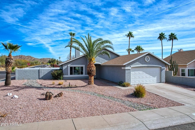 ranch-style home featuring a garage and a mountain view