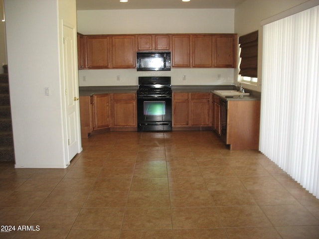 kitchen with black appliances, light tile patterned floors, and sink