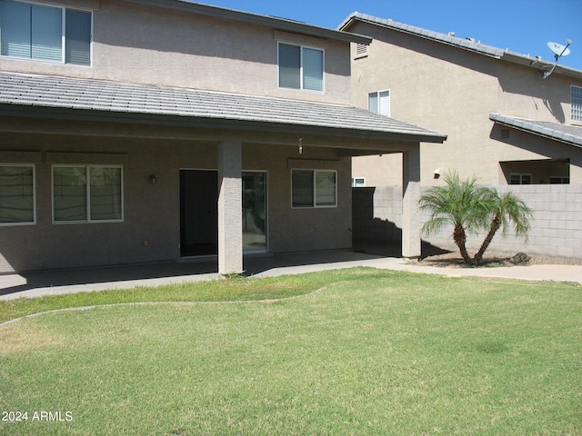 back of property featuring a lawn