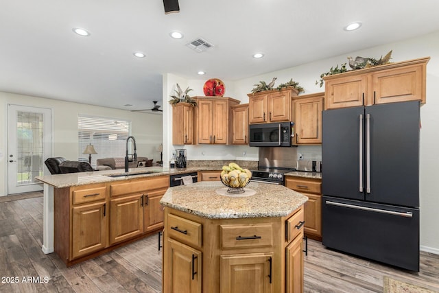 11312 E Newcastle Ave, Mesa, AZ 85209 - kitchen featuring black appliances, a kitchen island, wood finished floors, light stone counters, and recessed lighting