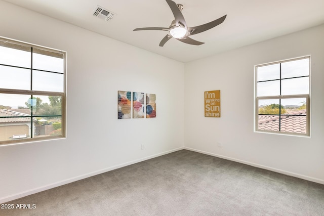 empty room with ceiling fan, plenty of natural light, and carpet floors