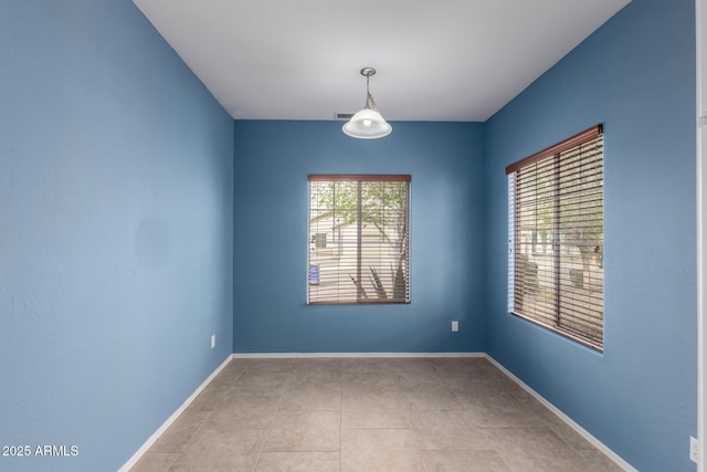 unfurnished room with tile patterned flooring and baseboards