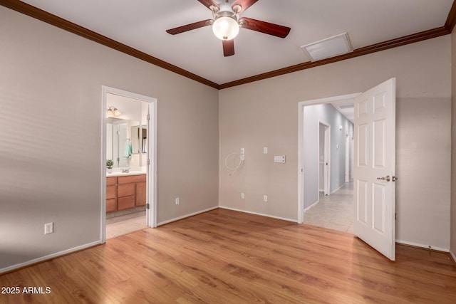 unfurnished bedroom with a sink, baseboards, light wood-style floors, and ornamental molding