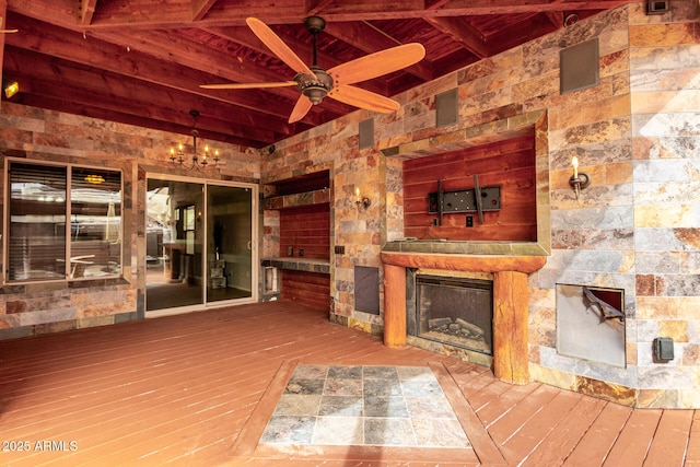 exterior space with a glass covered fireplace and a ceiling fan