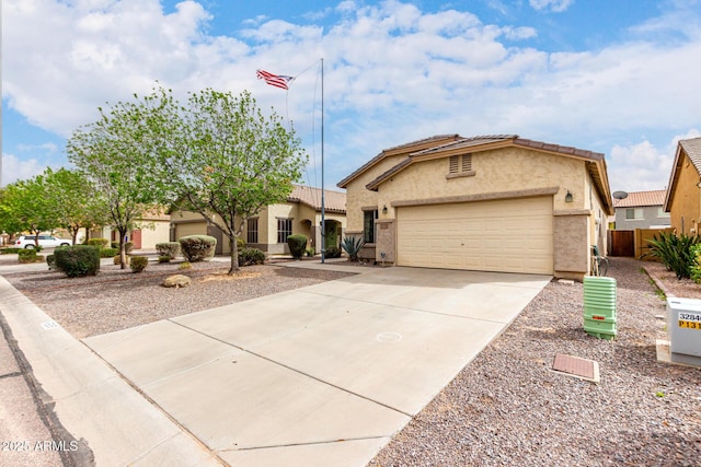 mediterranean / spanish-style house with a tile roof, a garage, driveway, and stucco siding