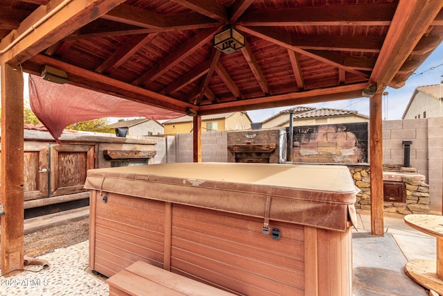 view of patio / terrace with a gazebo, fence, and a hot tub