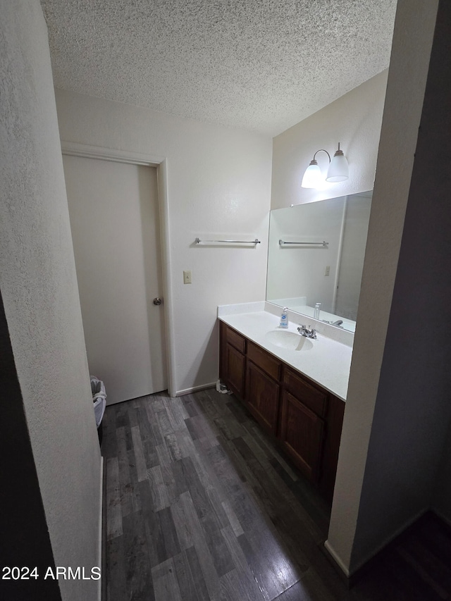 bathroom featuring hardwood / wood-style floors, vanity, and a textured ceiling