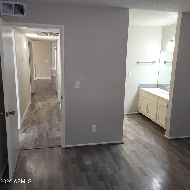 hallway with dark hardwood / wood-style flooring, sink, and a textured ceiling