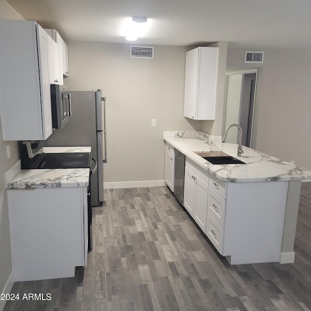 kitchen with sink, light stone counters, white cabinets, stainless steel dishwasher, and kitchen peninsula