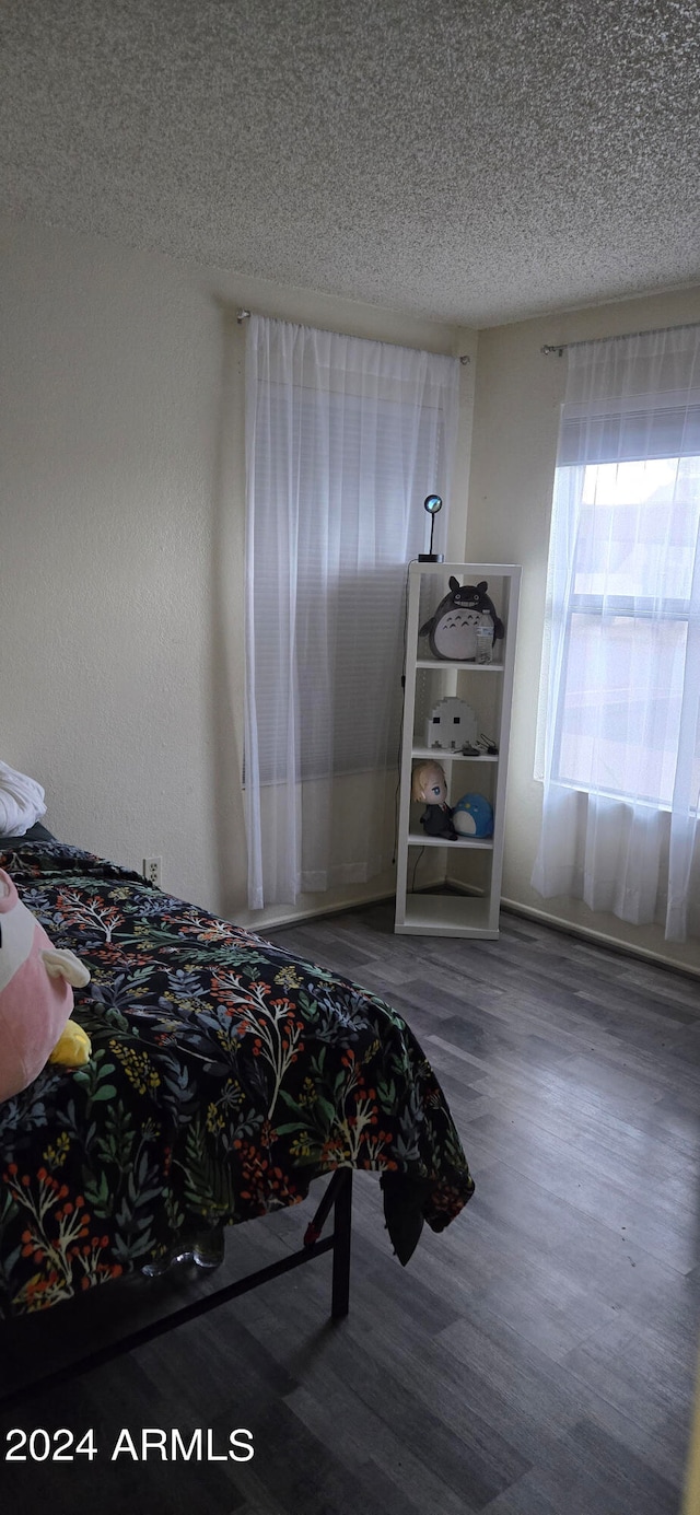 bedroom featuring hardwood / wood-style floors and a textured ceiling