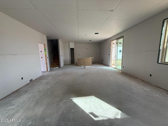 interior space featuring unfinished concrete flooring and stairs