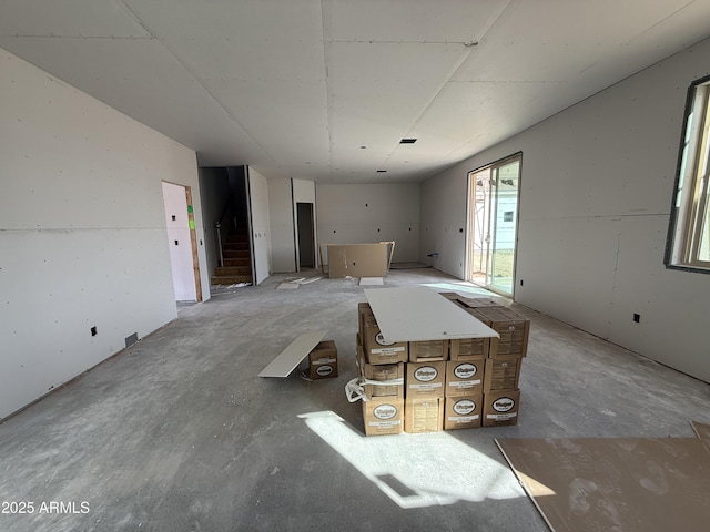 interior space featuring concrete flooring and stairs