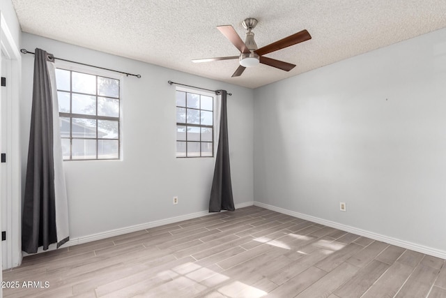 spare room featuring a textured ceiling, ceiling fan, and light hardwood / wood-style flooring