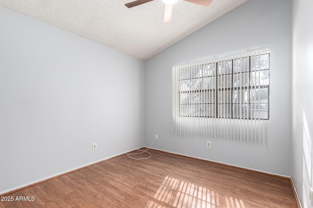 spare room with ceiling fan, lofted ceiling, wood-type flooring, and a textured ceiling