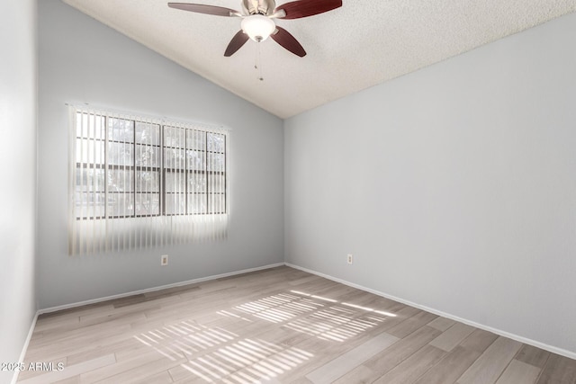 unfurnished room featuring lofted ceiling, ceiling fan, light hardwood / wood-style floors, and a textured ceiling