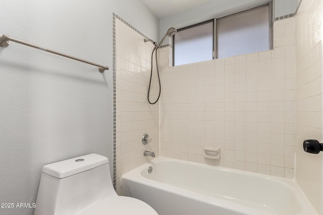 bathroom with tiled shower / bath and toilet