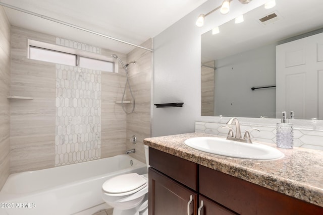 full bathroom featuring tiled shower / bath, vanity, and toilet