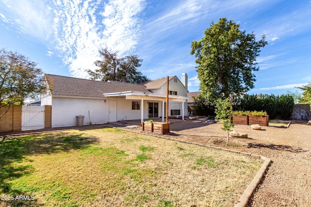 back of house with a yard and a patio