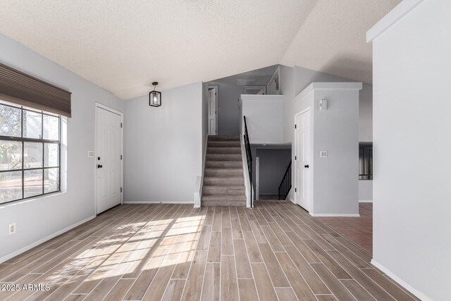 entryway featuring vaulted ceiling and a textured ceiling