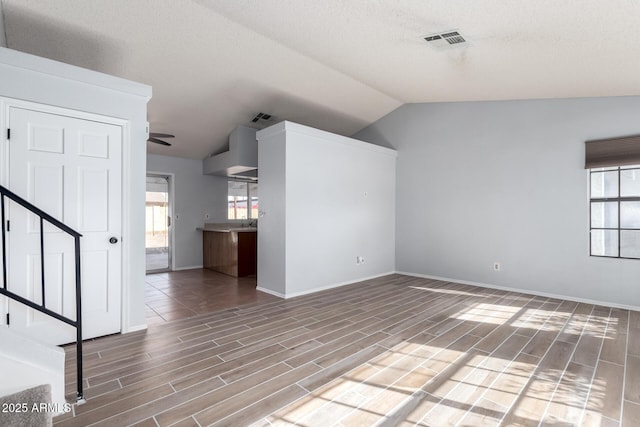 unfurnished living room with lofted ceiling, a healthy amount of sunlight, and ceiling fan