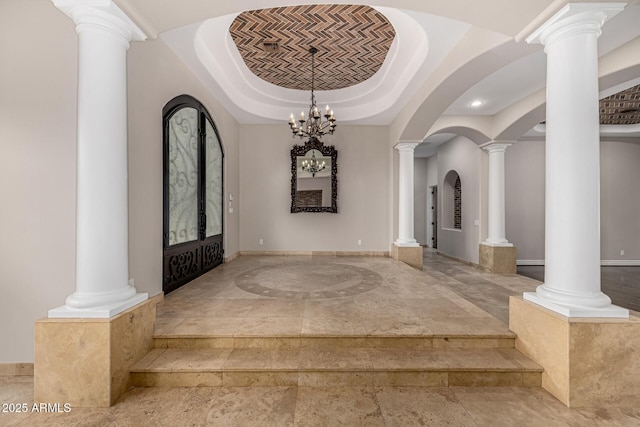 foyer entrance with a chandelier, french doors, and a tray ceiling