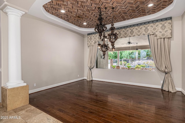 unfurnished dining area with ceiling fan, brick ceiling, decorative columns, and hardwood / wood-style floors