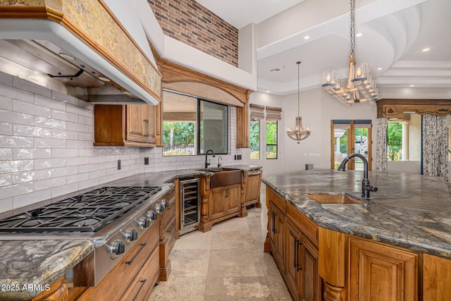 kitchen featuring sink, pendant lighting, dark stone countertops, and custom exhaust hood