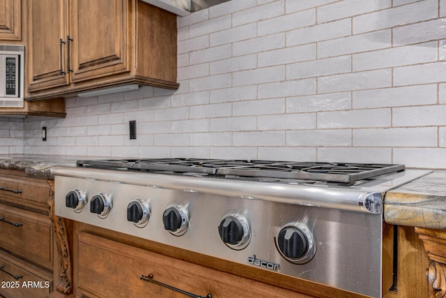 room details with decorative backsplash and appliances with stainless steel finishes