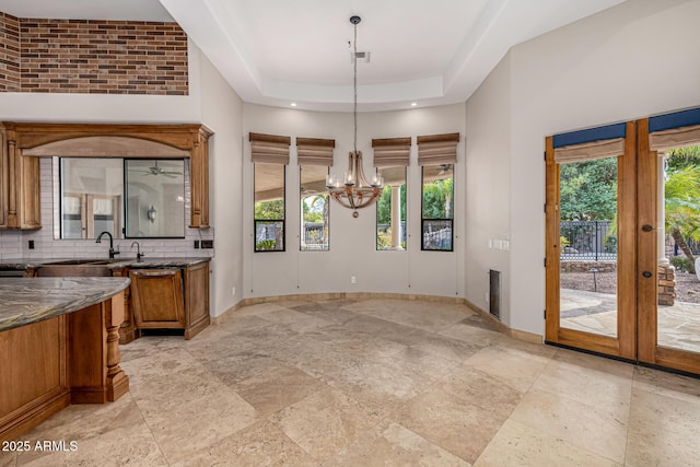 unfurnished dining area featuring plenty of natural light, french doors, sink, and a chandelier