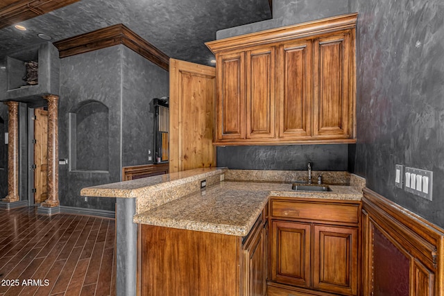 kitchen with a kitchen breakfast bar, kitchen peninsula, sink, and ornamental molding