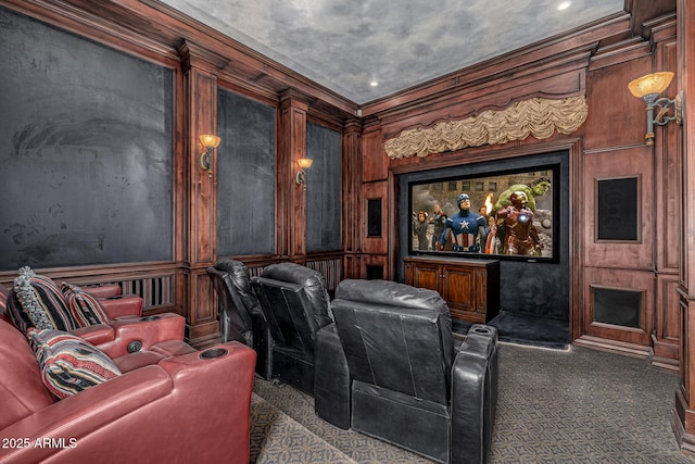 home theater with ornamental molding and dark colored carpet